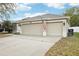 Double garage doors on a home with an American flag out front and a wide driveway at 3206 Hurley Grove Way, Valrico, FL 33596