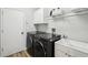 Modern laundry room features front load washer and dryer, utility sink, white cabinets, and wood look flooring at 3206 Hurley Grove Way, Valrico, FL 33596