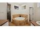 This ensuite bathroom has an oval soaking tub with tile surround, plus a tiled shower at 3206 Hurley Grove Way, Valrico, FL 33596