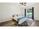 This main bedroom boasts wood flooring, ceiling fan, and sliding doors to the back yard at 3206 Hurley Grove Way, Valrico, FL 33596