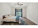 This main bedroom has wood flooring, a ceiling fan, and sliding doors to the back yard at 3206 Hurley Grove Way, Valrico, FL 33596