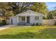 Charming single-story home with a gray brick facade, manicured lawn, and mature shade tree at 404 W Alva St, Tampa, FL 33603