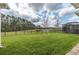 Expansive backyard with lush green lawn, wrought iron fence, and a lake view at 4206 Tour Trce, Land O Lakes, FL 34638