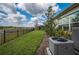 Backyard view of black wrought iron fence with retention pond beyond the lush landscaping at 4206 Tour Trce, Land O Lakes, FL 34638