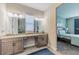 Open-concept bathroom showcasing double vanities, tile flooring, and a bedroom view at 4206 Tour Trce, Land O Lakes, FL 34638