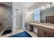 Bright bathroom showcasing double vanities, a glass shower, and tile flooring at 4206 Tour Trce, Land O Lakes, FL 34638