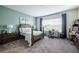 Comfortable bedroom featuring a queen-size bed, neutral carpet, and a well-lit desk area at 4206 Tour Trce, Land O Lakes, FL 34638