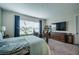 Cozy bedroom with a queen-size bed, a large window, carpet, and a wall-mounted TV at 4206 Tour Trce, Land O Lakes, FL 34638