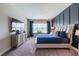 Bedroom with navy accent wall, plush carpet, a comfortable bed, and a dresser under a mounted TV at 4206 Tour Trce, Land O Lakes, FL 34638