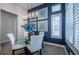 Dining area featuring a glass table, white chairs, a blue accent wall, and shuttered windows at 4206 Tour Trce, Land O Lakes, FL 34638