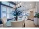 Dining area with glass table, white chairs, blue accent wall, and open view to kitchen and living room at 4206 Tour Trce, Land O Lakes, FL 34638