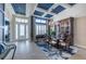 Bright dining area with coffered ceiling, chandelier, and view of the front door at 4206 Tour Trce, Land O Lakes, FL 34638