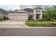 Elegant home features a three-car garage, well-manicured lawn, and contemporary architectural details at 4206 Tour Trce, Land O Lakes, FL 34638
