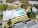 Aerial view of a relaxing pool area with shuffleboard in a well-maintained community with tree-lined streets at 4215 E Bay Dr # 1701C, Clearwater, FL 33764