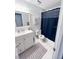 Clean bathroom with vanity, framed mirror, and a shower with a navy curtain at 4215 E Bay Dr # 1701C, Clearwater, FL 33764