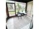 Enclosed lanai with tile flooring, a bistro table, and seating overlooking the community at 4215 E Bay Dr # 1701C, Clearwater, FL 33764