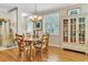 Cozy dining room with hardwood floors, an elegant chandelier, and natural light from a window with white shutters at 4266 Preserve Pl # 4266, Palm Harbor, FL 34685