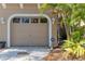 Garage and driveway with beautiful tropical foliage at 4266 Preserve Pl # 4266, Palm Harbor, FL 34685