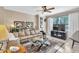 Comfortable living room featuring a plush sofa, decorative accents, a ceiling fan, and a large window at 4266 Preserve Pl # 4266, Palm Harbor, FL 34685