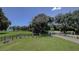 Entrance to Lansbrook Lakefront Park with manicured lawns, mature trees and a view of the lake at 4266 Preserve Pl # 4266, Palm Harbor, FL 34685