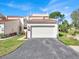 Exterior view of the home featuring a two car garage, landscaping, and manicured lawn at 4312 Sunray Ct # 36, Tampa, FL 33615