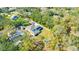 Aerial view showcasing the property's layout, pool, and surrounding lush greenery and neighborhood at 4411 Culbreath Rd, Valrico, FL 33596