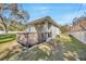 Back exterior view of home featuring a wooden porch, partial lawn, and a privacy fence at 4411 Culbreath Rd, Valrico, FL 33596