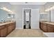 Bright bathroom with double vanities, granite countertops, and neutral tile flooring at 4411 Culbreath Rd, Valrico, FL 33596