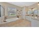Spa-like bathroom featuring a soaking tub, separate shower, and dual sinks with granite counters at 4411 Culbreath Rd, Valrico, FL 33596