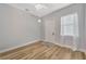 Bright bedroom featuring hardwood floors, a ceiling fan, a window with sheer curtains, and a white door at 4411 Culbreath Rd, Valrico, FL 33596