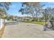A sprawling home nestled on a well-manicured lot, enhanced by a large shade tree and expansive paved driveway at 4411 Culbreath Rd, Valrico, FL 33596