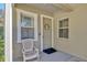 Inviting front entry with a neutral door, decorative wreath, and a comfortable chair at 4411 Culbreath Rd, Valrico, FL 33596
