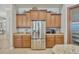 The kitchen features stainless steel refrigerator and brown cabinets with granite countertops at 4411 Culbreath Rd, Valrico, FL 33596
