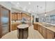 Spacious kitchen with brown wood cabinetry, granite counters, a center island, and stainless appliances at 4411 Culbreath Rd, Valrico, FL 33596