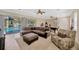 Cozy living room with a comfortable seating area, a billiards table, and a view of the outdoor pool at 4411 Culbreath Rd, Valrico, FL 33596