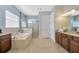 Spacious main bathroom with a soaking tub, glass shower, and double vanity at 4411 Culbreath Rd, Valrico, FL 33596