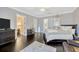 Relaxing primary bedroom with dark wood floors, a decorative chandelier, and ensuite bathroom at 4411 Culbreath Rd, Valrico, FL 33596