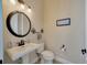 Classic half bathroom with a pedestal sink, a round mirror, and neutral décor at 4411 Culbreath Rd, Valrico, FL 33596