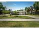 Charming single-story home with a well-manicured lawn, palm trees, and a long driveway on a sunny day at 4500 22Nd S Ave, St Petersburg, FL 33711