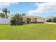 Attractive one-level house with a well-maintained lawn, mature plants, and a white fence at 4912 Bay Park Dr, Port Richey, FL 34668