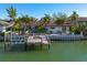Backyard canal with water access, a boat dock, and lush landscaping in a tropical setting at 4959 58Th S Ave, St Petersburg, FL 33715