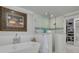 A bright bathroom featuring a soaking tub, frameless shower, and access to a walk-in closet at 4959 58Th S Ave, St Petersburg, FL 33715