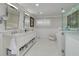 Bright bathroom featuring double sinks, white cabinets, marble countertops, and glass-enclosed shower at 4959 58Th S Ave, St Petersburg, FL 33715