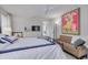 Light filled bedroom with a white dresser, sofa, and a bed with navy blue and white bedding at 4959 58Th S Ave, St Petersburg, FL 33715