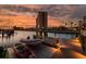Picturesque waterfront view featuring a private dock with boat lift against a vibrant sunset backdrop at 4959 58Th S Ave, St Petersburg, FL 33715