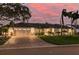 Beautiful single-story home featuring a white exterior, well-manicured lawn, brick driveway and lush landscaping at 4959 58Th S Ave, St Petersburg, FL 33715
