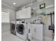Laundry room with a washer, dryer, white cabinets and gray walls at 4959 58Th S Ave, St Petersburg, FL 33715