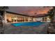 A stunning backyard pool surrounded by a patio, with an outdoor dining area, and a covered lounge space at 4959 58Th S Ave, St Petersburg, FL 33715