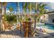 Outdoor seating area with wooden chairs and a table beside a pool, providing space for outdoor entertainment at 4959 58Th S Ave, St Petersburg, FL 33715