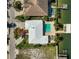 Aerial shot of property with a pool, dock, boat lift, and lush landscaping at 5105 W Longfellow Ave, Tampa, FL 33629
